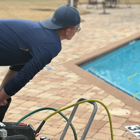 Technician performing a single-line pool plumbing pressure test