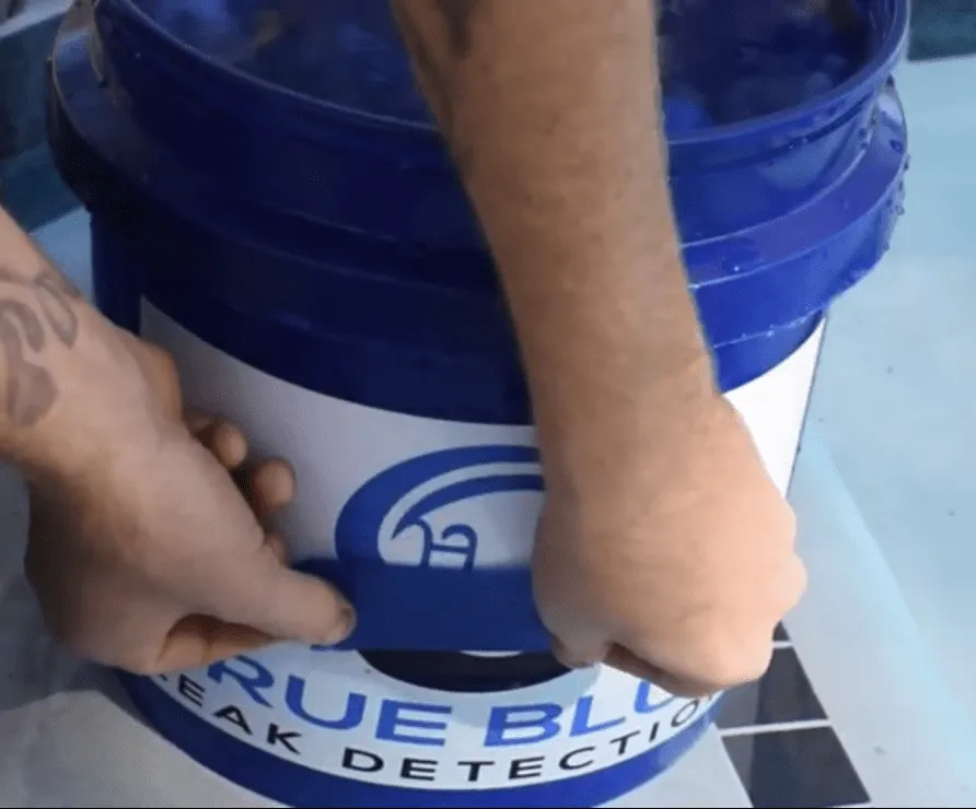 Tape marking the pool-water level outside a bucket